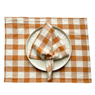 Tischset und Serviette als Set aus Baumwolle. Karomuster in den Farben beige und orange.